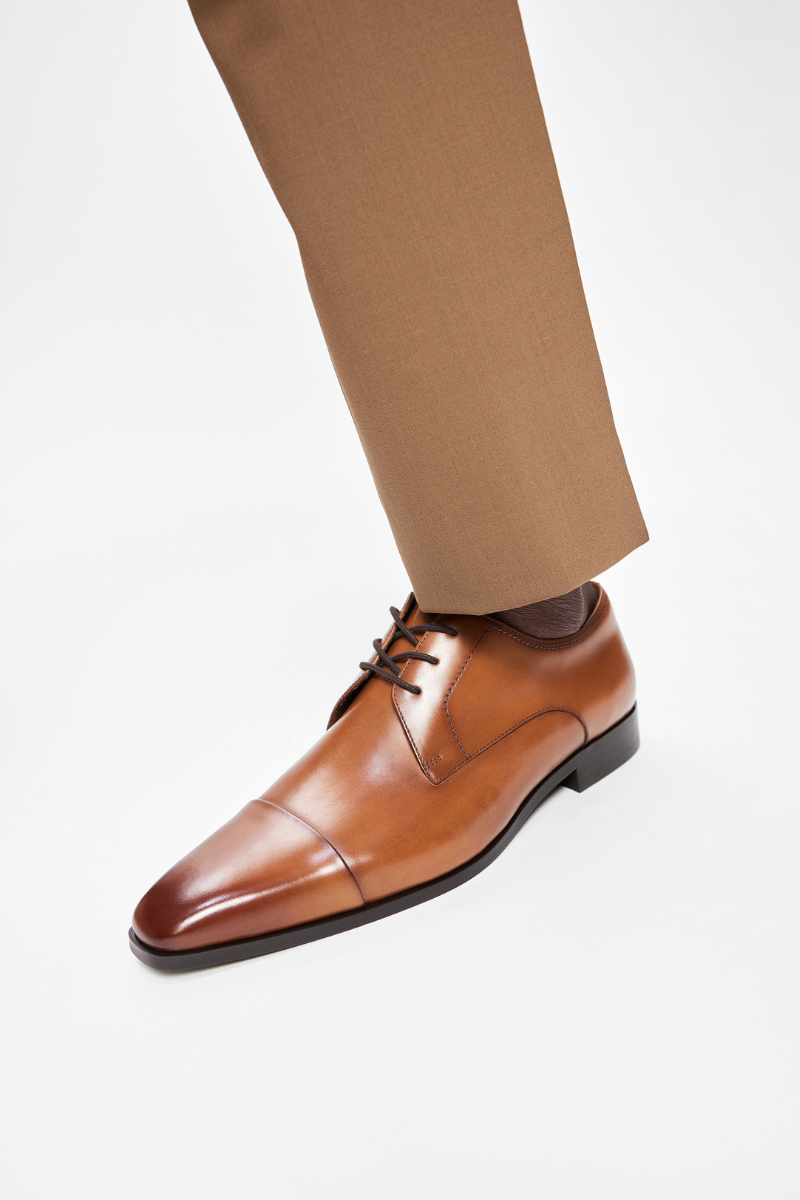 leg of a mam wearing a classic leather shoe in brown