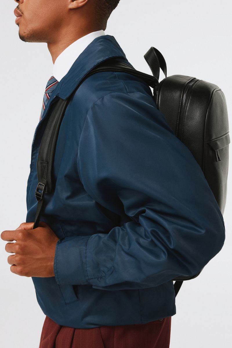 Black minimalist leather backpack with top zipper.