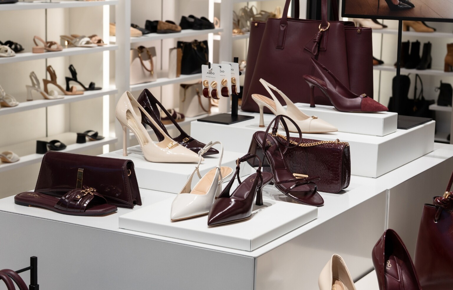 Interior de uma loja ALDO com expositores de sapatos e malas femininas.