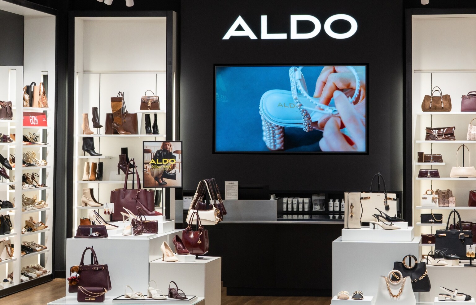 Interior de una tienda ALDO con expositores de zapatos y bolsos femeninos.