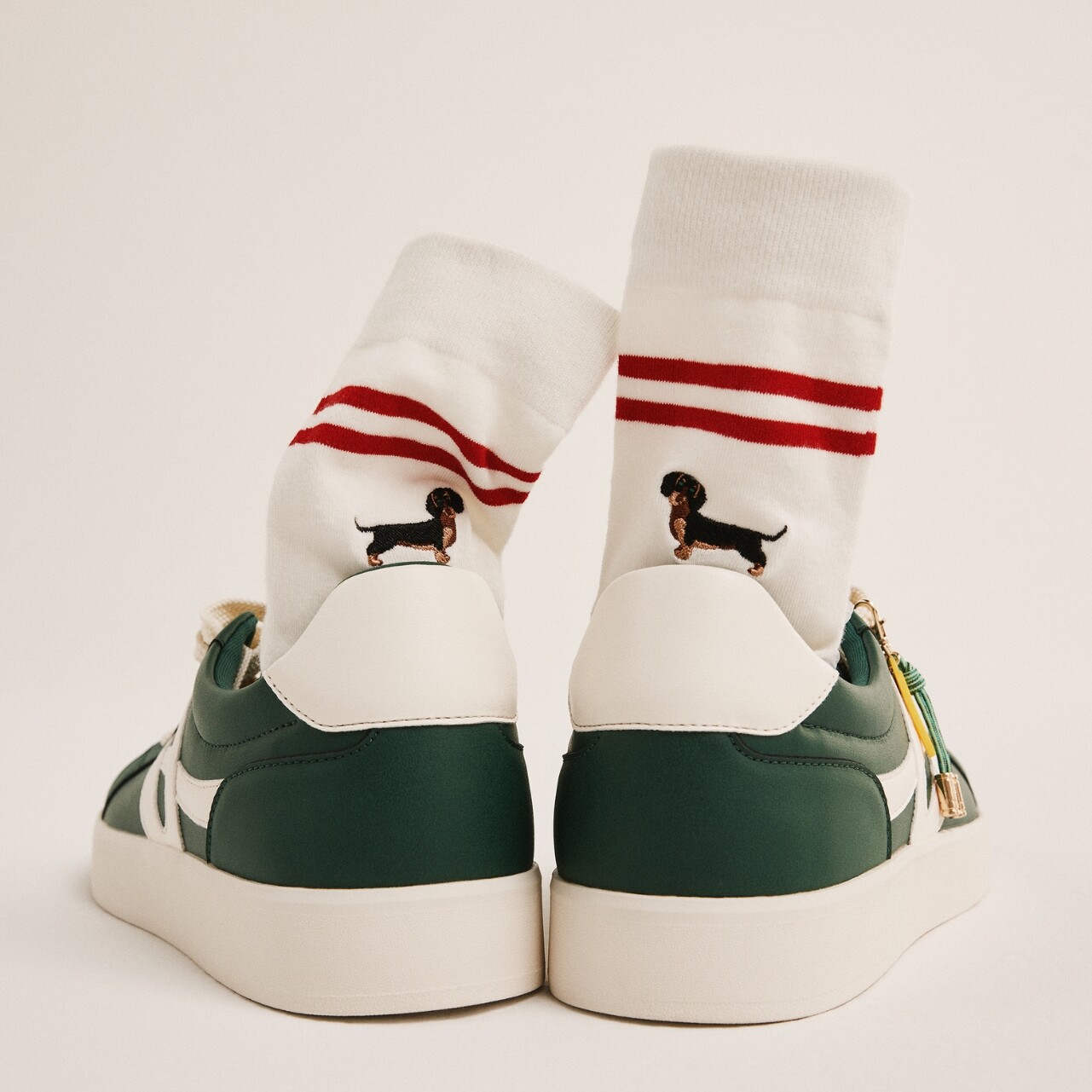 Zapatillas deportivas verdes de hombre con calcetines blancos.