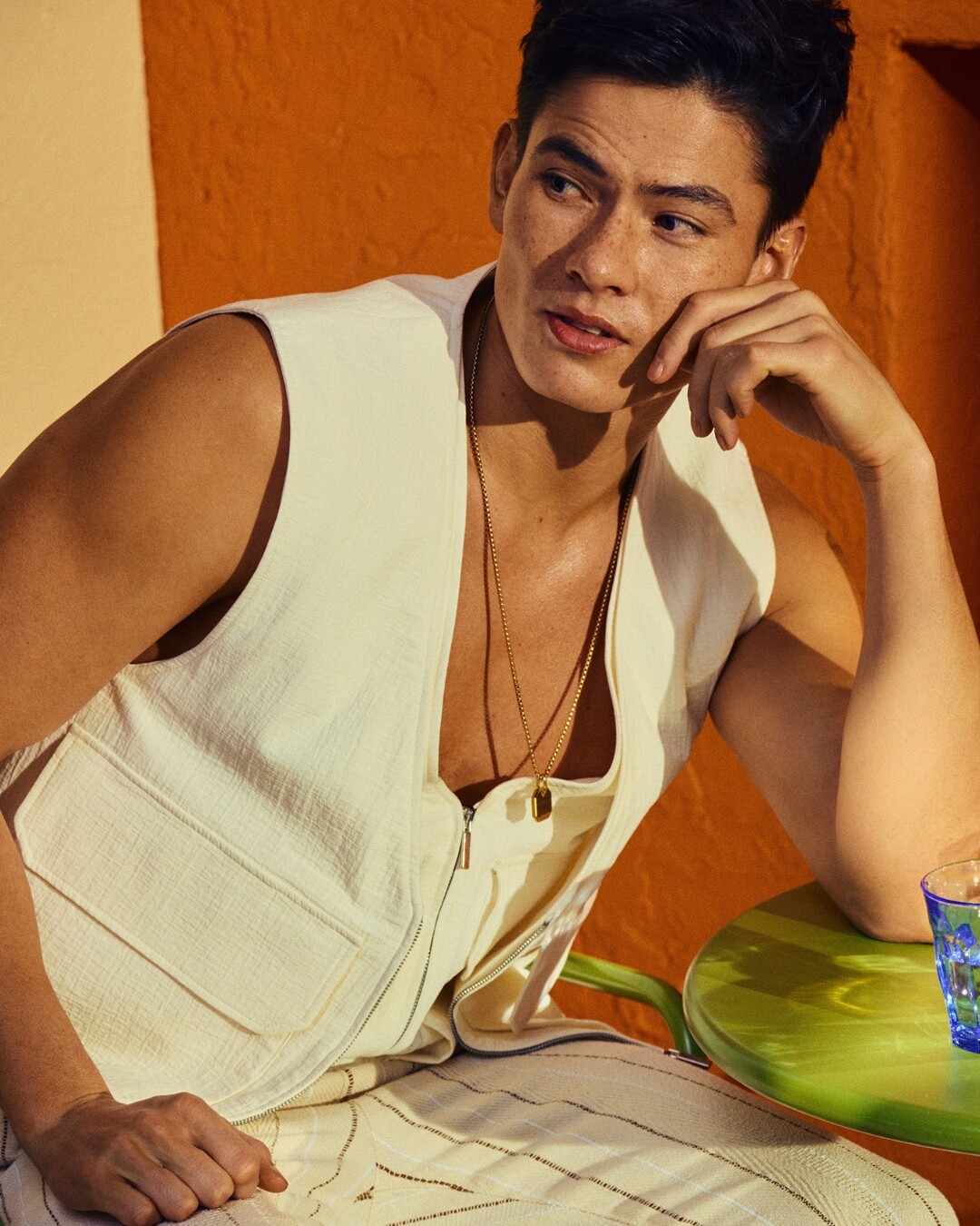 Hombre con chaleco beige en mesa verde.