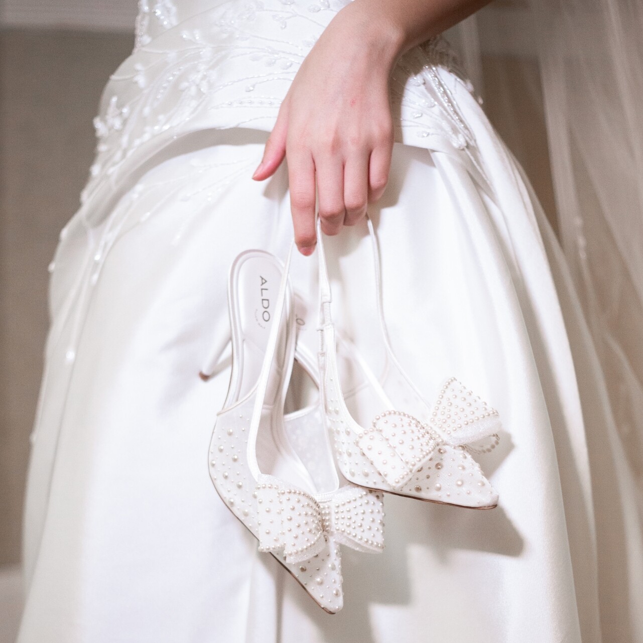 Zapatos de novia blancos con lazos y perlas decorativas.