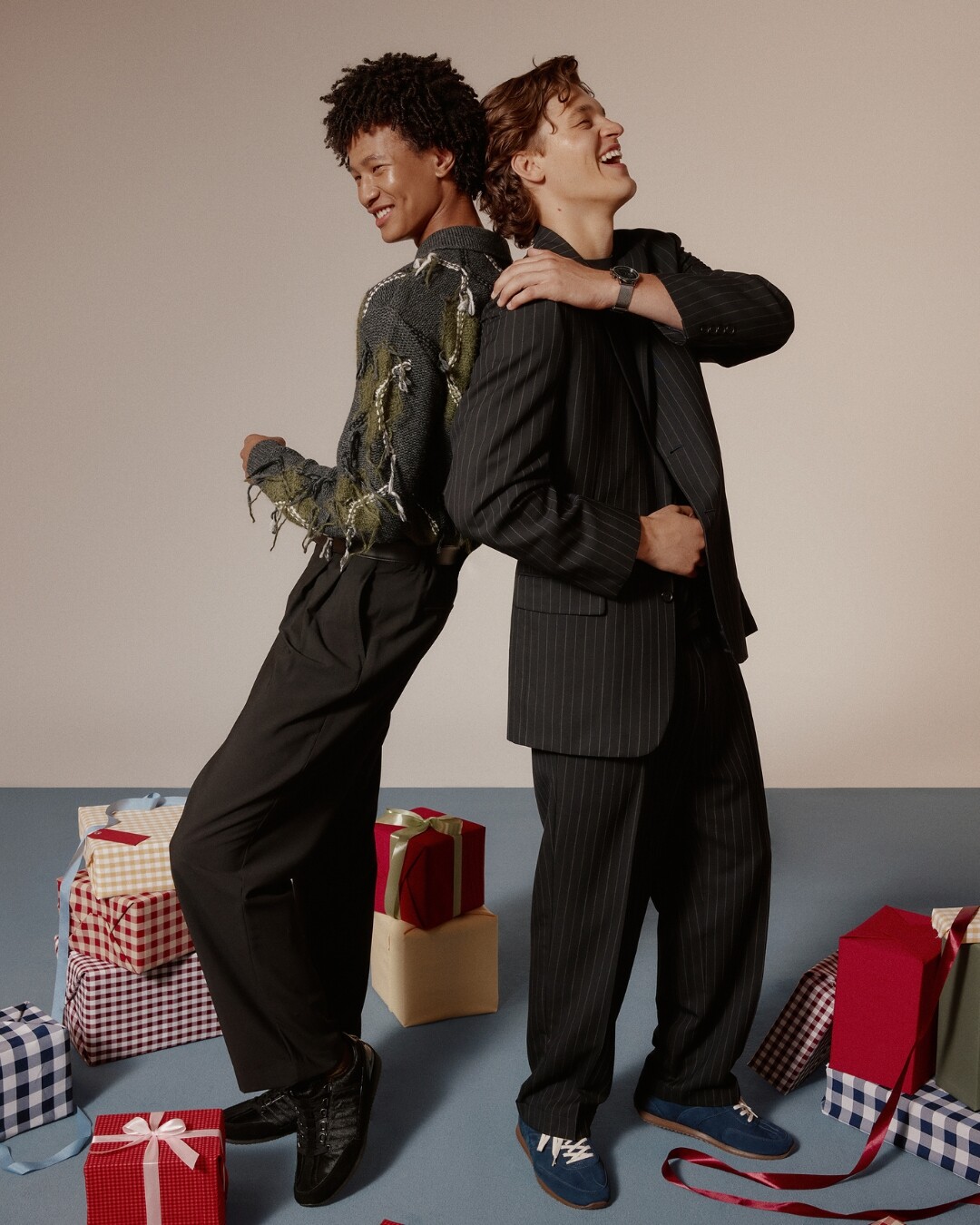 Dos hombres con zapatos casuales de fiesta, rodeados de regalos.