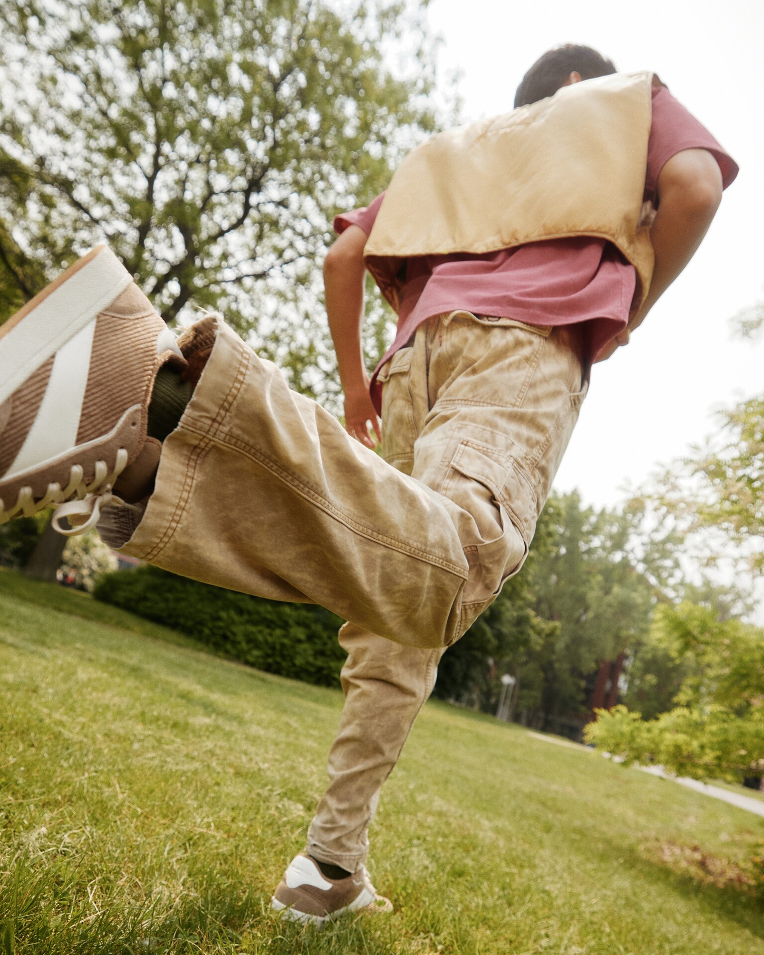 Hombre en movimiento con zapatillas ALDO en tonos neutros al aire libre.
