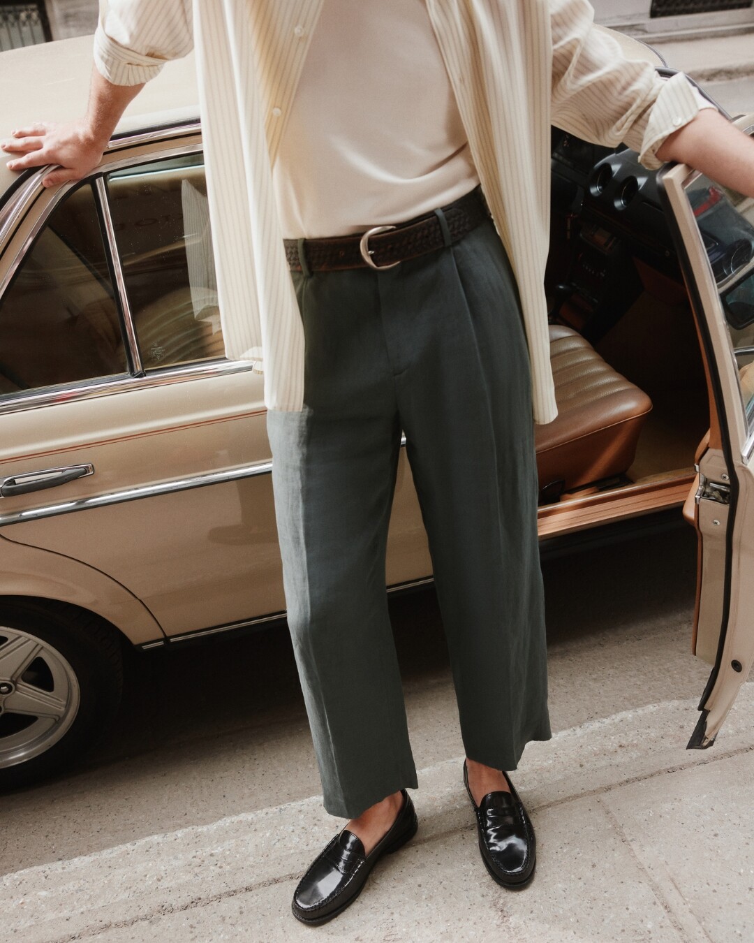 Mocassins pretos ALDO em pele envernizada, combinados com calças verde-escuro.