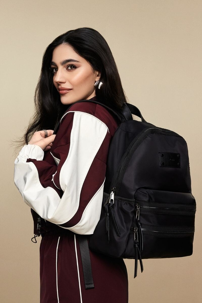 Mochila preta em nylon com vários bolsos e fechos frontais.