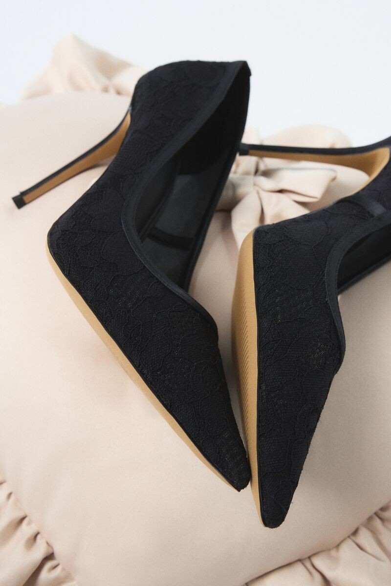 Sapatos slingback pretos em renda com salto alto fino.
