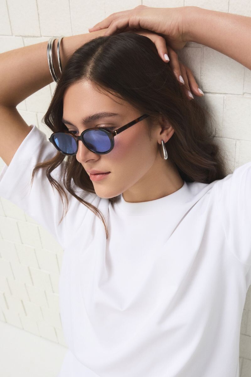 Óculos de sol com armação tartaruga e lentes azuis.