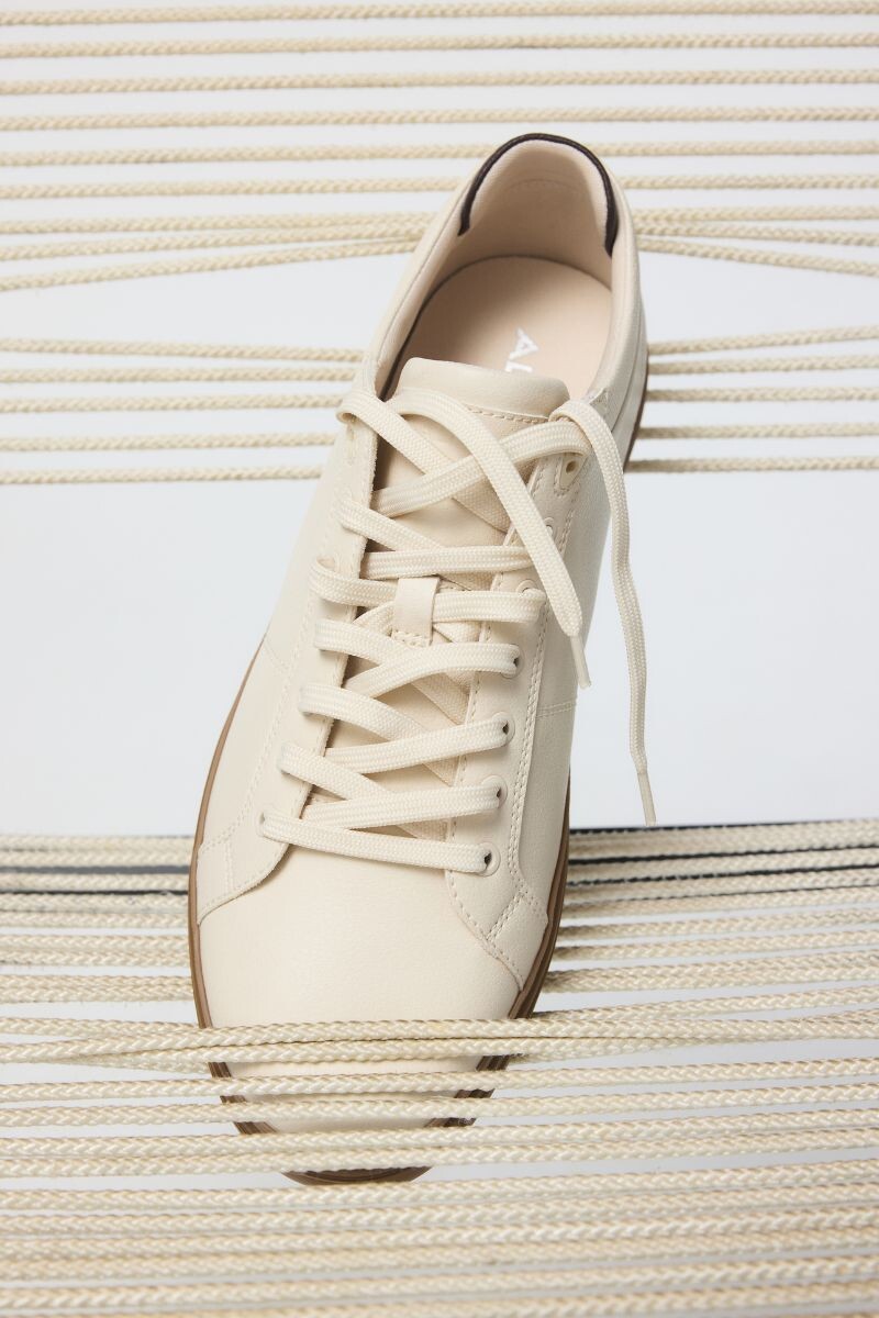 Zapatilla beige de piel con cordones y suela de goma.