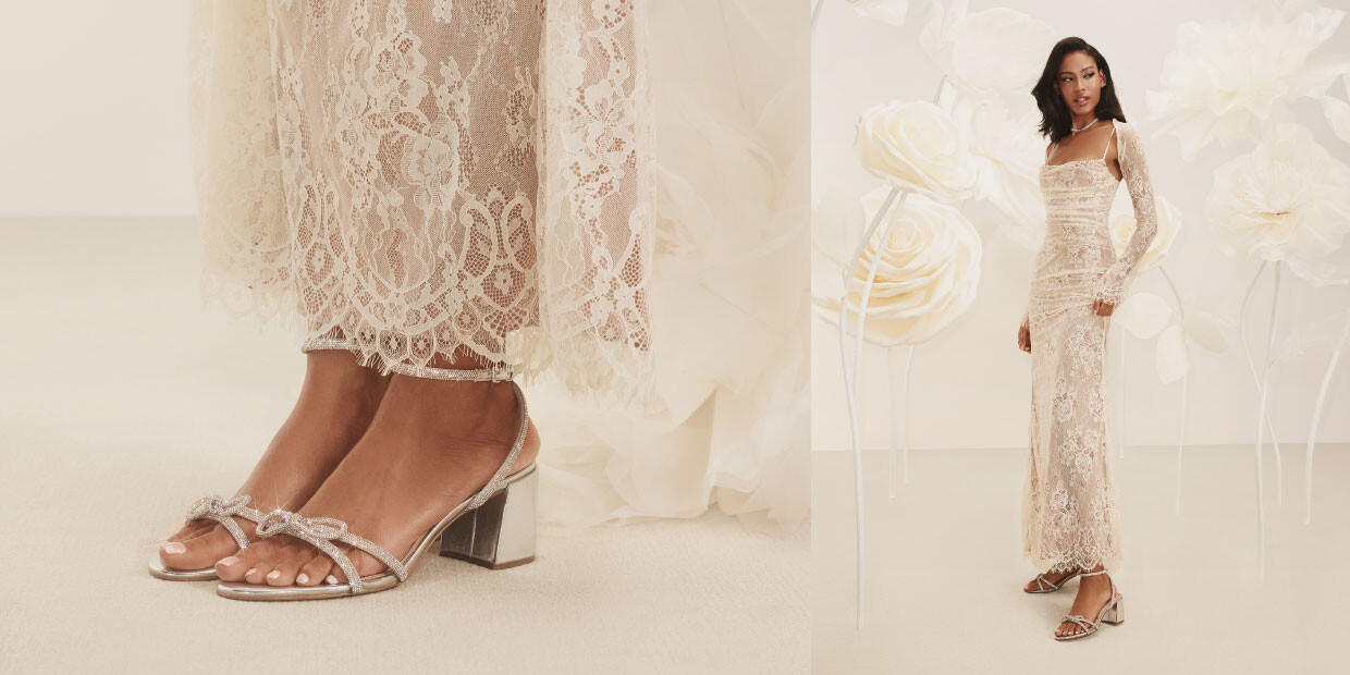 noiva de vestido rendado a calçar sapatos prateados com brilhantes e salto em bloco sobre um fundo claro com flores brancas