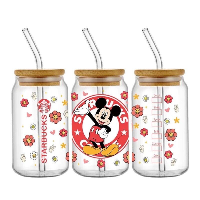 São mostrados três copos transparentes em estilo frasco de vidro com tampas de bambu e canudos de vidro. Eles apresentam padrões de flores coloridas e ilustrações do Mickey Mouse. O vidro central tem uma imagem grande do Mickey Mouse, enquanto os out