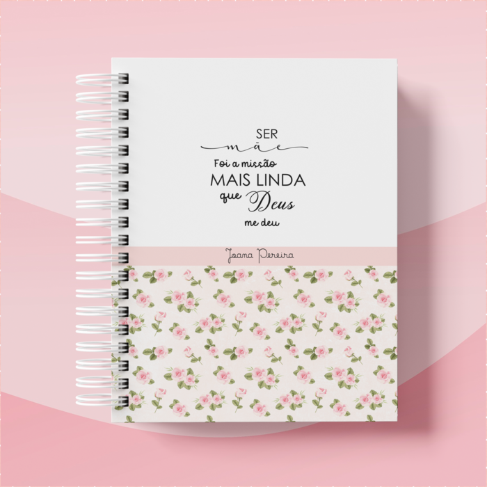 Caderno espiral com metade inferior floral e texto manuscrito em português na metade superior, sobre fundo rosa suave.