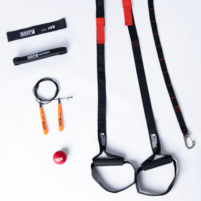 Black suspension straps with handles, resistance loops, orange-handled jump rope and red massageball