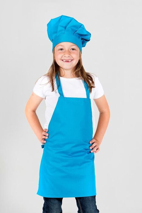 Criança sorridente com chapéu e avental de cozinheiro azul turquesa sobre t‑shirt branca
