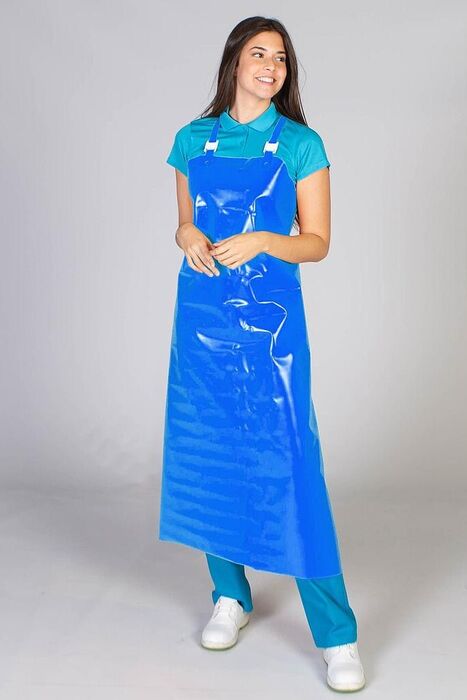 Mulher sorridente a usar avental impermeável azul comprido sobre roupa médica