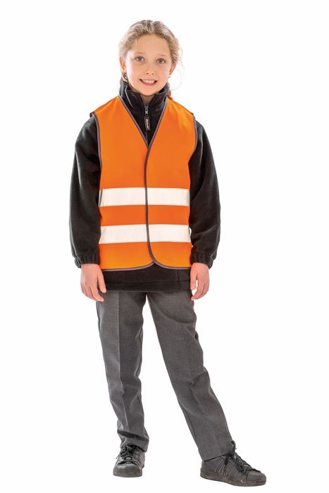 Criança de pé com colete refletor laranja com duas faixas refletoras horizontais