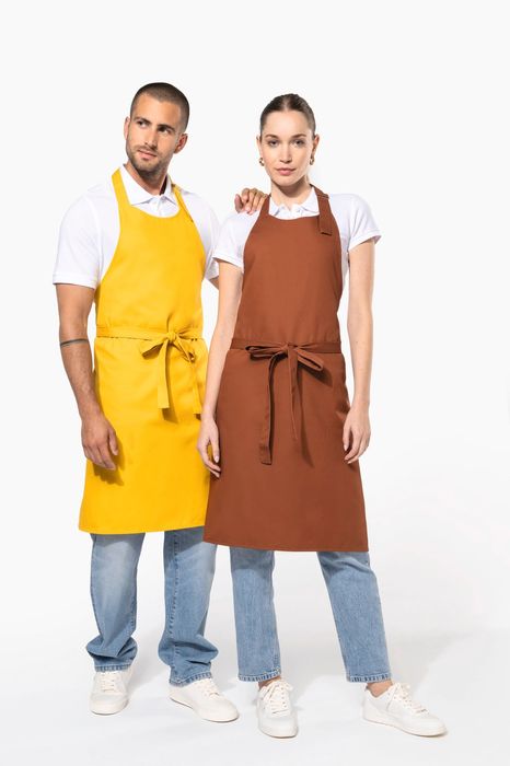 Dois modelos com aventais de cozinha sem bolso, um amarelo e outro castanho
