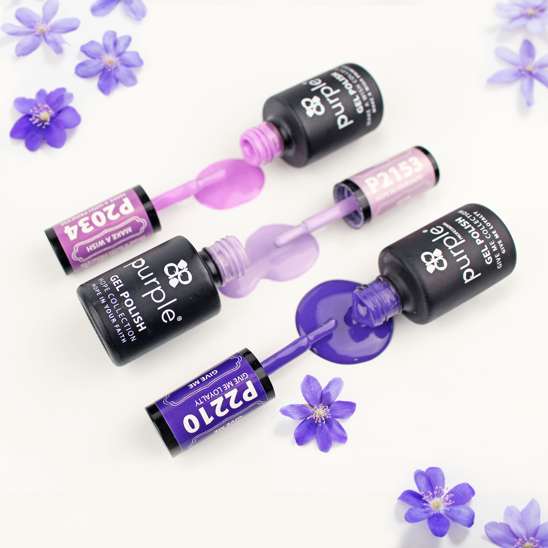 Verniz gel da marca Purple com 3 tons de roxo entornado numa superfície branca. 