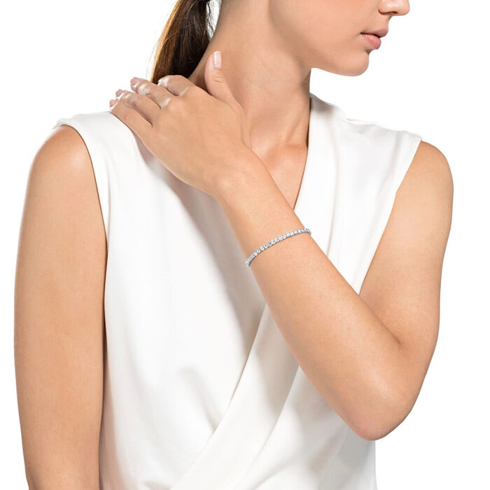 Modelo feminino com uma pulseira Swarovski em prateado com uma malha cravada de cristais incolores.
