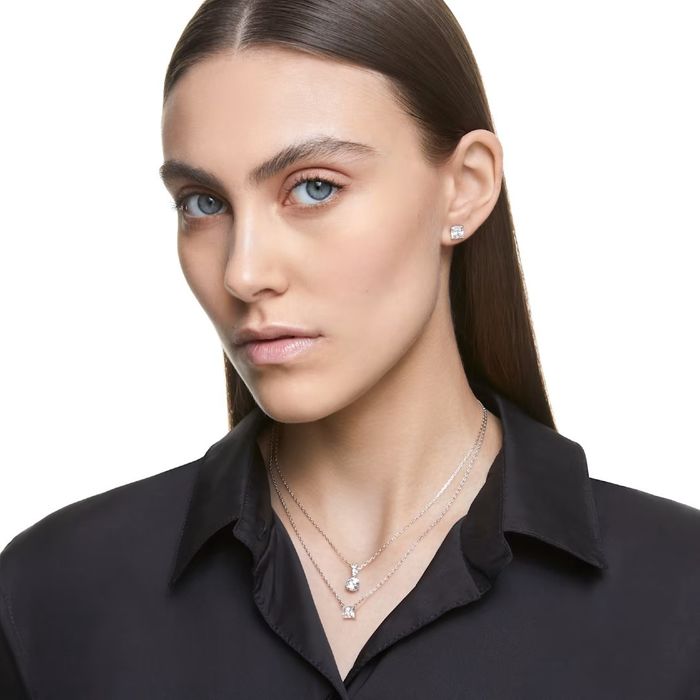 Modelo com um brinco prateado Swarovski com um cristal quadrangular incolor engastadas em garras.