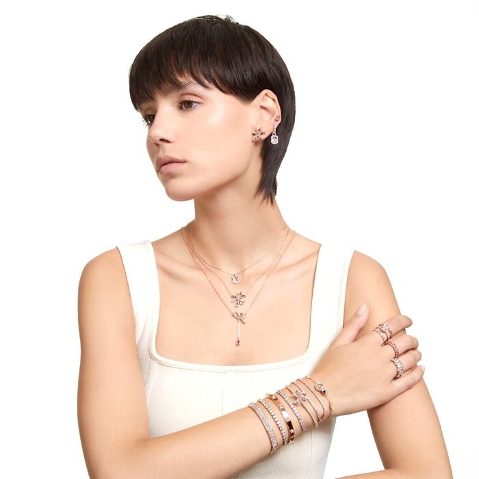 Modelo feminino com joias em rose gold da Swarovski cravados de cristais incolores.