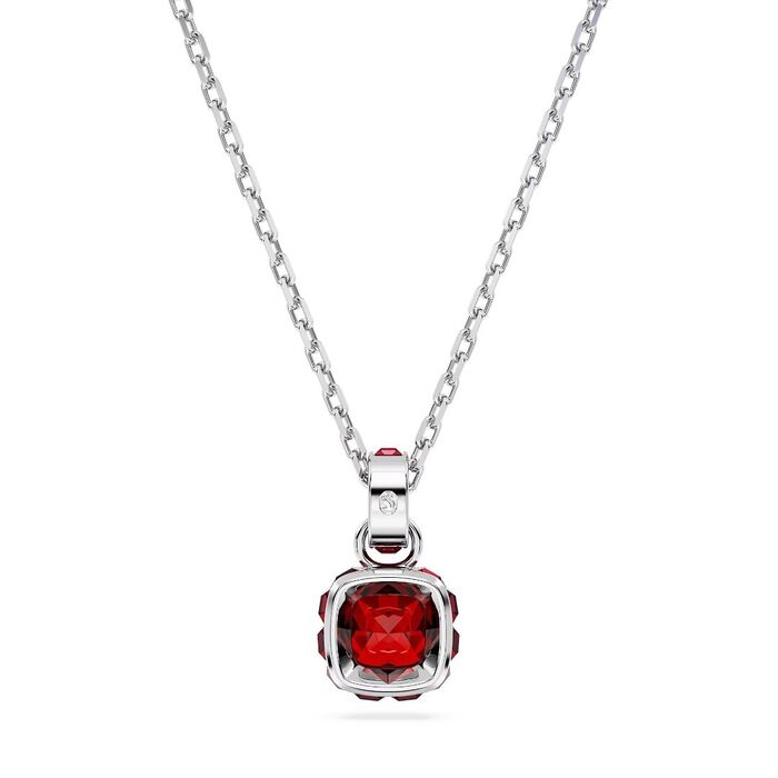 Vista traseira de um colar prateado Swarovski com um pendente com cristais e uma pedra vermelha.