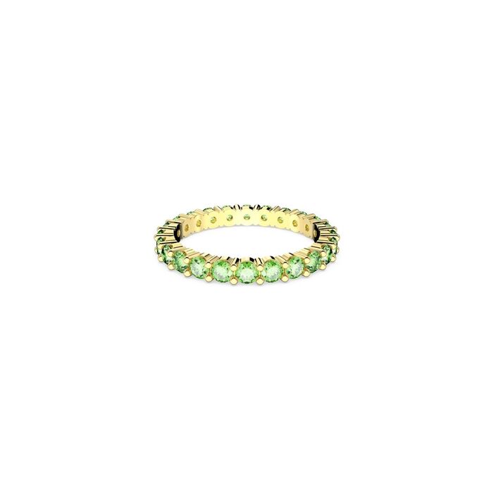 Vista frontal de anel dourado da Swarovski pousado e cravado de cristais verdes circulares.