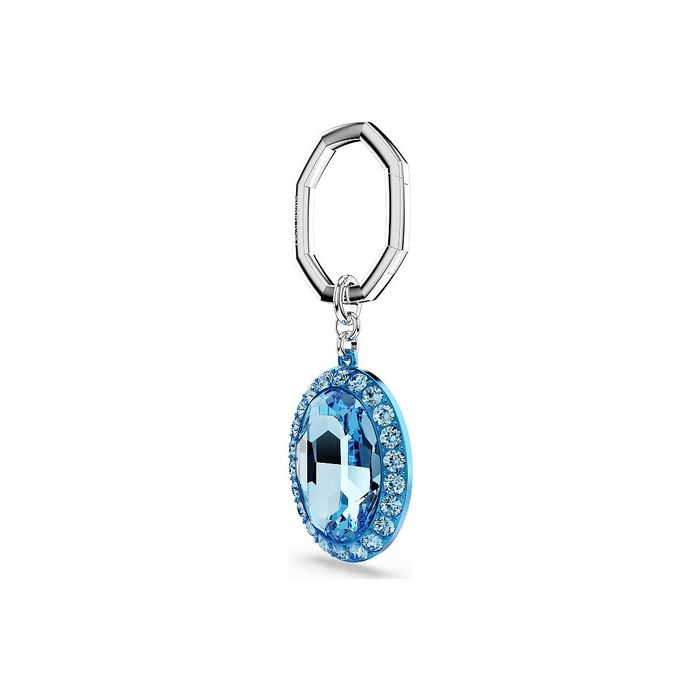 Porta-chaves prateado Swarovski, de lado, com um pendente com cristais e uma pedra azul no centro.