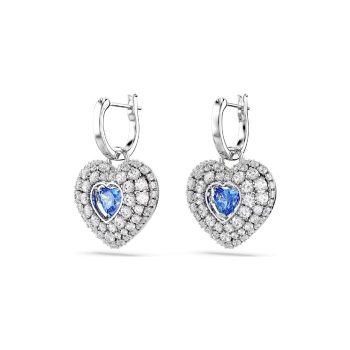 Argolas prateadas Swarovski, de lado, com um coração com cristais incolores e uma azul no centro.