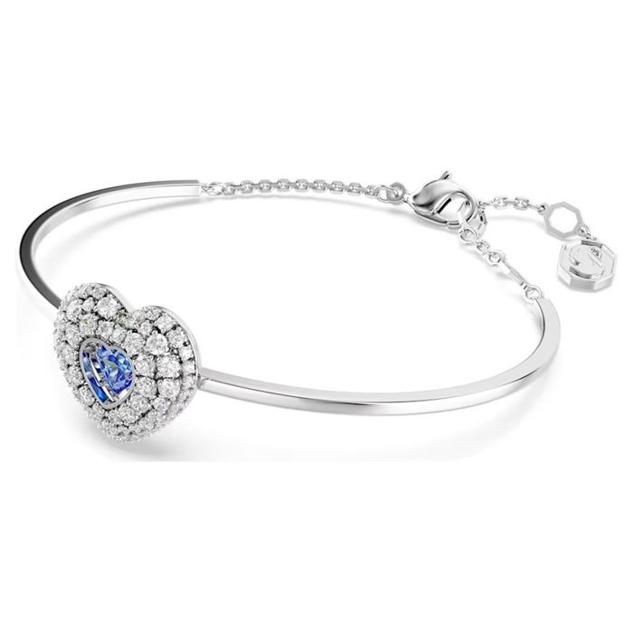 Pulseira prateada Swarovski, em vista lateral, com um coração com cristais e uma azul no centro.