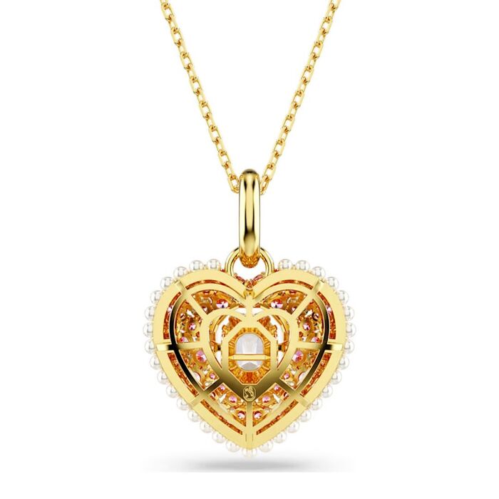Vista de trás de um colar dourado Swarovski com um pendente em coração com pérolas à volta.