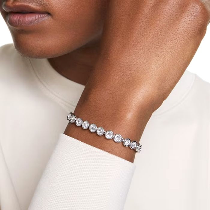 Modelo feminino com um pulseira prateada Swarovski com malha de bases circulares com cristais.