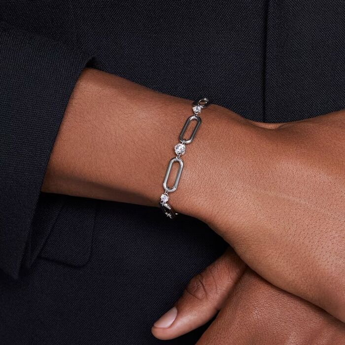 Pulso de modelo feminino com uma pulseira prateada Swarovski com cristais cravados entre elos.