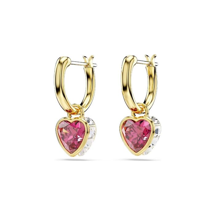 Argolas Swarovski, de lado, com um pendente em forma de coração com um cristal vermelho no centro.