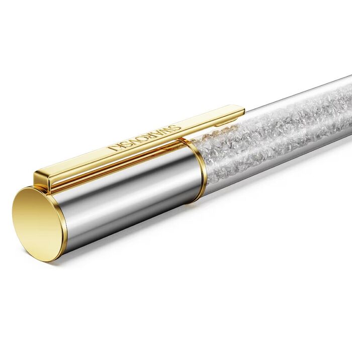 Detalhe do lado superior de uma esferográfica Swarovski prateada de clip dourado e pedras no centro.