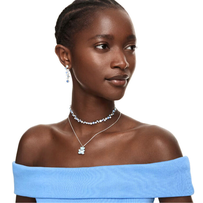 Modelo feminina com brincos da Swarovski, de formato pendente comprido com cristais azuis e brancos.