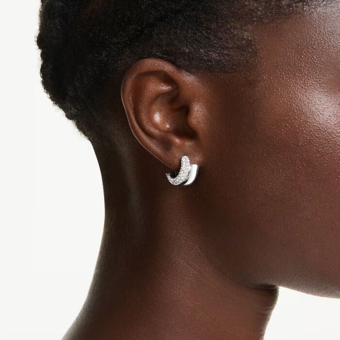 Brincos prateados com cristais swarovski estilo de argola na orelha da modelo.
