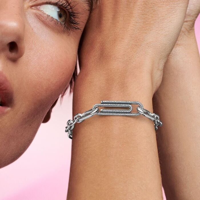 Modelo com uma pulseira ligada a uma conta Pandora Me em forma de um clip cravada de zircónias.