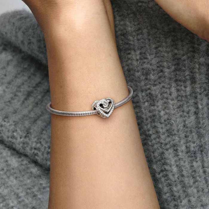 Modelo com uma conta Pandora prateada em forma de coração com aros e cravada de zircónias.
