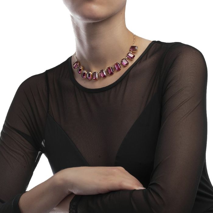 Modelo feminino com colar com cristais Swarovski roxos retangulares e banhado a ouro amarelo 18kl.