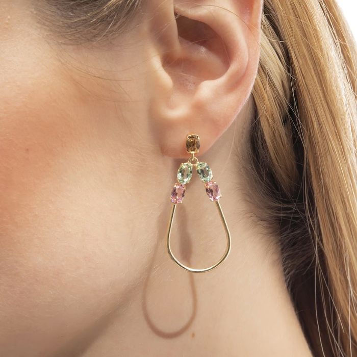 Modelo feminino com brincos Victoria Cruz em prata banhada a ouro com cristais Swarovski coloridos.