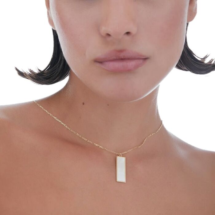Modelo com colar Victoria Cruz em prata banhada a ouro 18kl com pendente retangular com madrepérola.