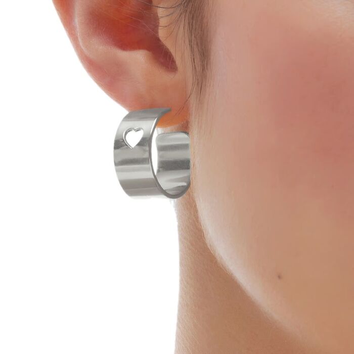 Modelo com uma argola Victoria Cruz em prata com um recorte em forma de coração no topo da joia.