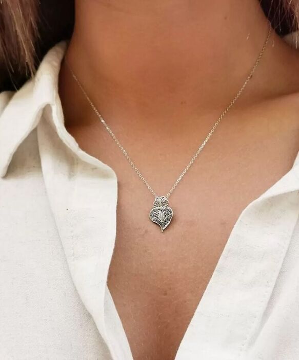 Modelo com um colar prateado Portugal Jewels com um pendente de um coração de viana em filigrana.