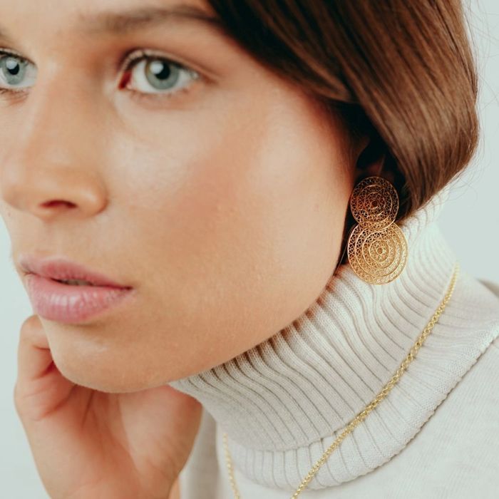 Modelo feminino com um brinco dourado Portugal Jewels com dois círculos em filigrana.