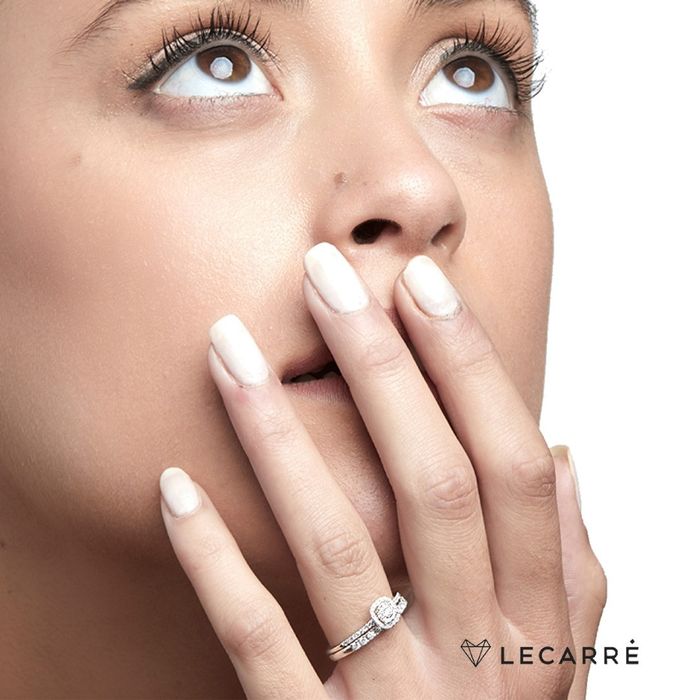 Modelo feminina com destaque na mão a usar anel ouro branco, com um diamantes cravados no topo.