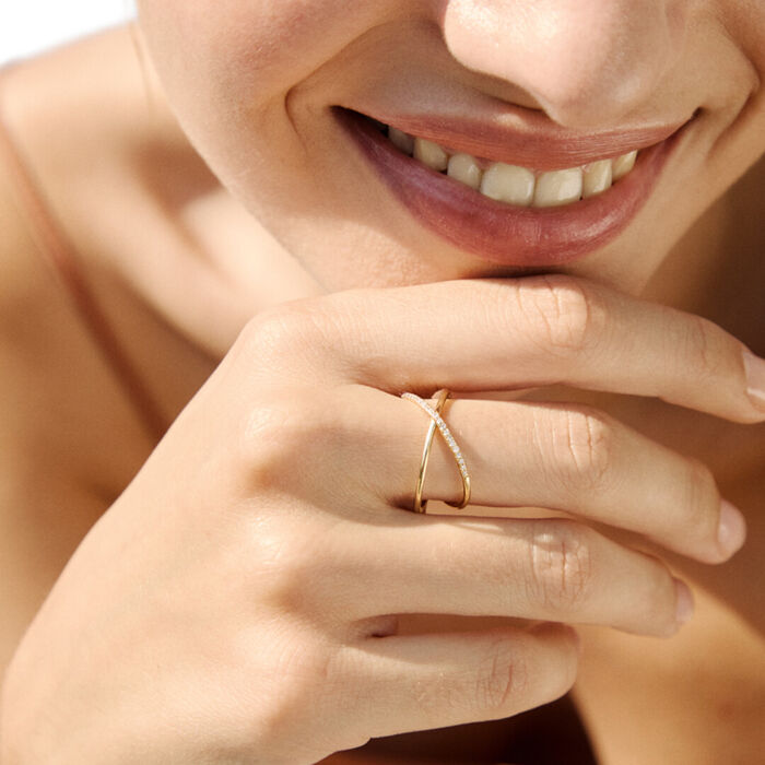 Mão feminina com anel LECARRÉ em ouro amarelo, com dois aros sobrepostos, um deles com diamantes.