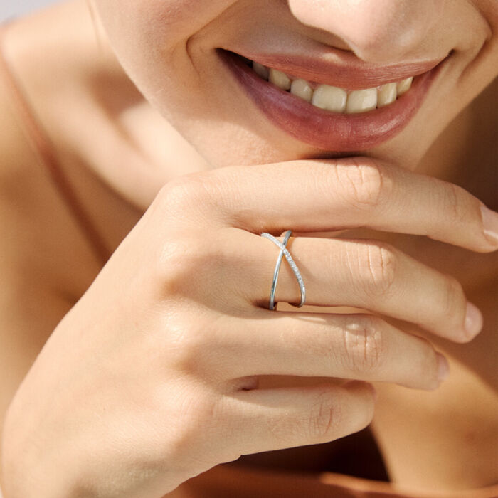 Mão feminina com anel LECARRÉ em ouro branco, com dois aros sobrepostos, um deles com diamantes.