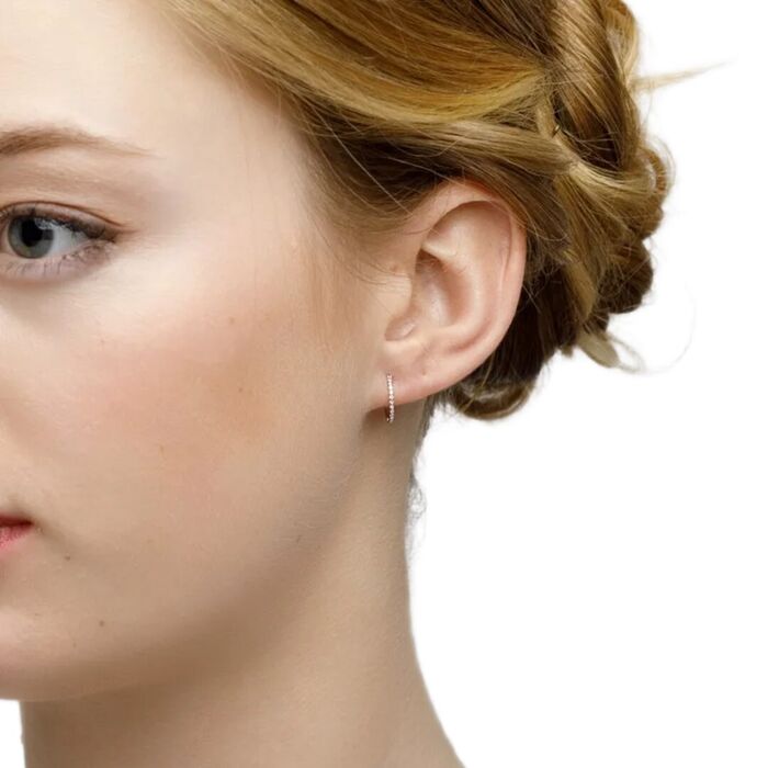 Modelo feminina em perfil, com argola LECARRÉ em ouro amarelo, com diamantes na parte frontal.